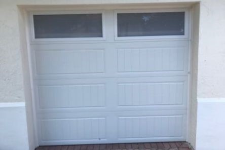 Close-up of newly installed double garage doors with decorative windows in San Marcos, TX.