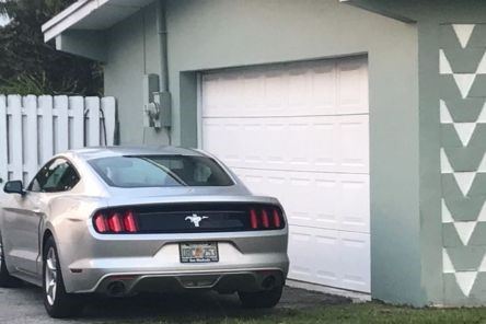 Silver Mustang parked outside newly repaired garage door in Buda home