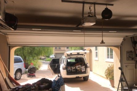 Garage interior with open door and technician's vehicle in driveway
