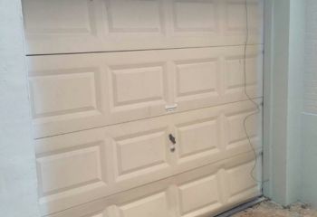 Old, worn-out garage door before replacement on Round Rock home.