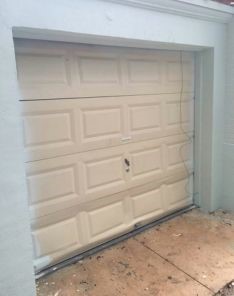 Old, worn-out garage door before replacement on Round Rock home.
