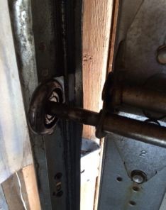Realigned garage door roller properly seated in the track after adjustment in Leander, TX